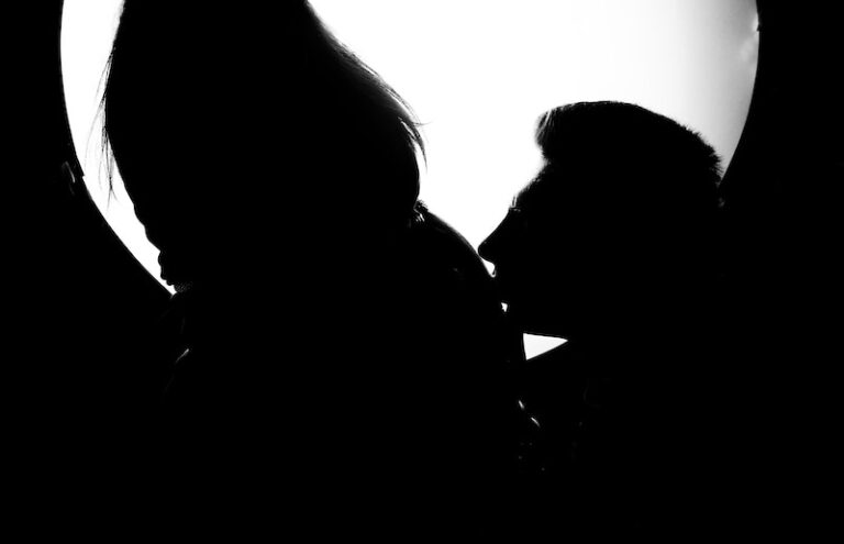 Silhouette of a Man Kissing the Tummy of a Pregnant Woman