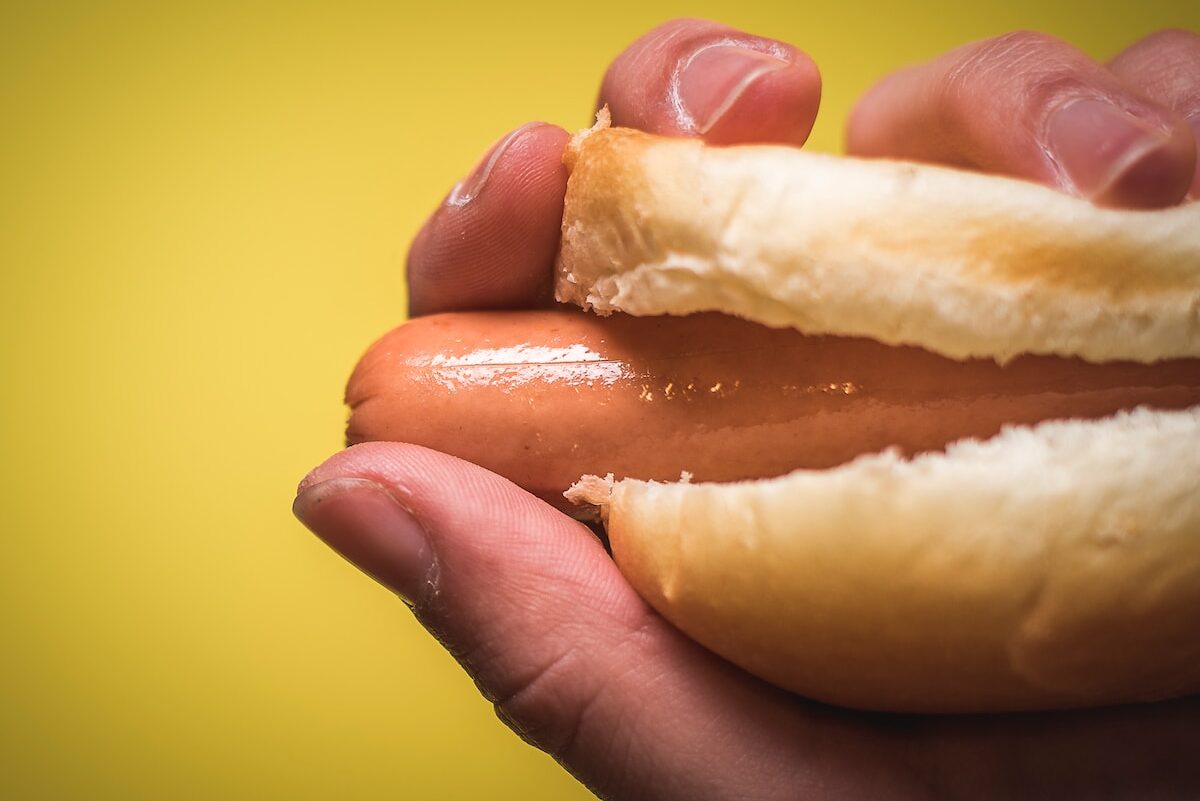 person holding sausage