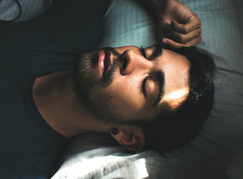 man in black crew neck t-shirt lying on bed